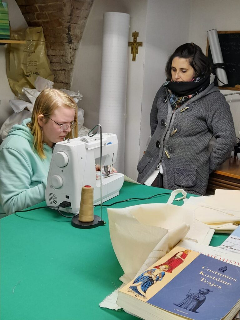 a woman sewing and another woman next to her
