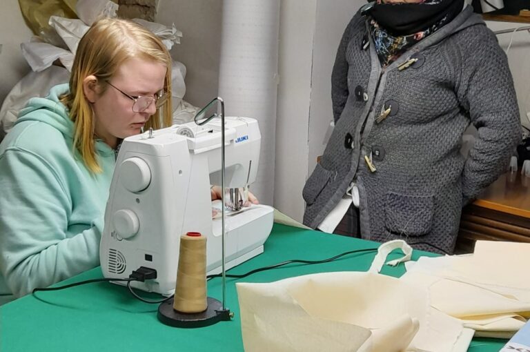 a woman sewing and another woman next to her