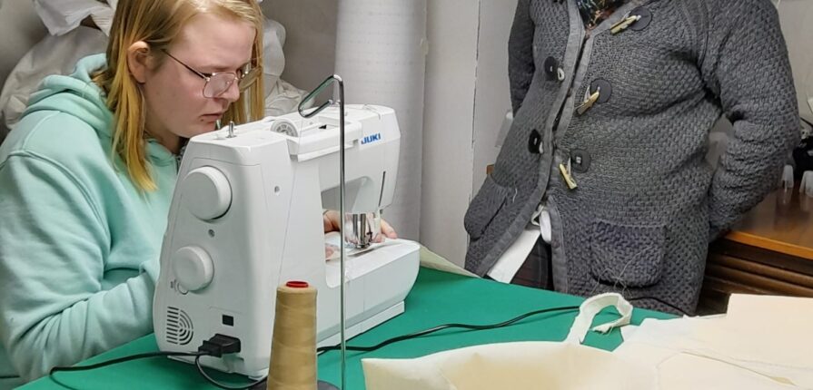 a woman sewing and another woman next to her